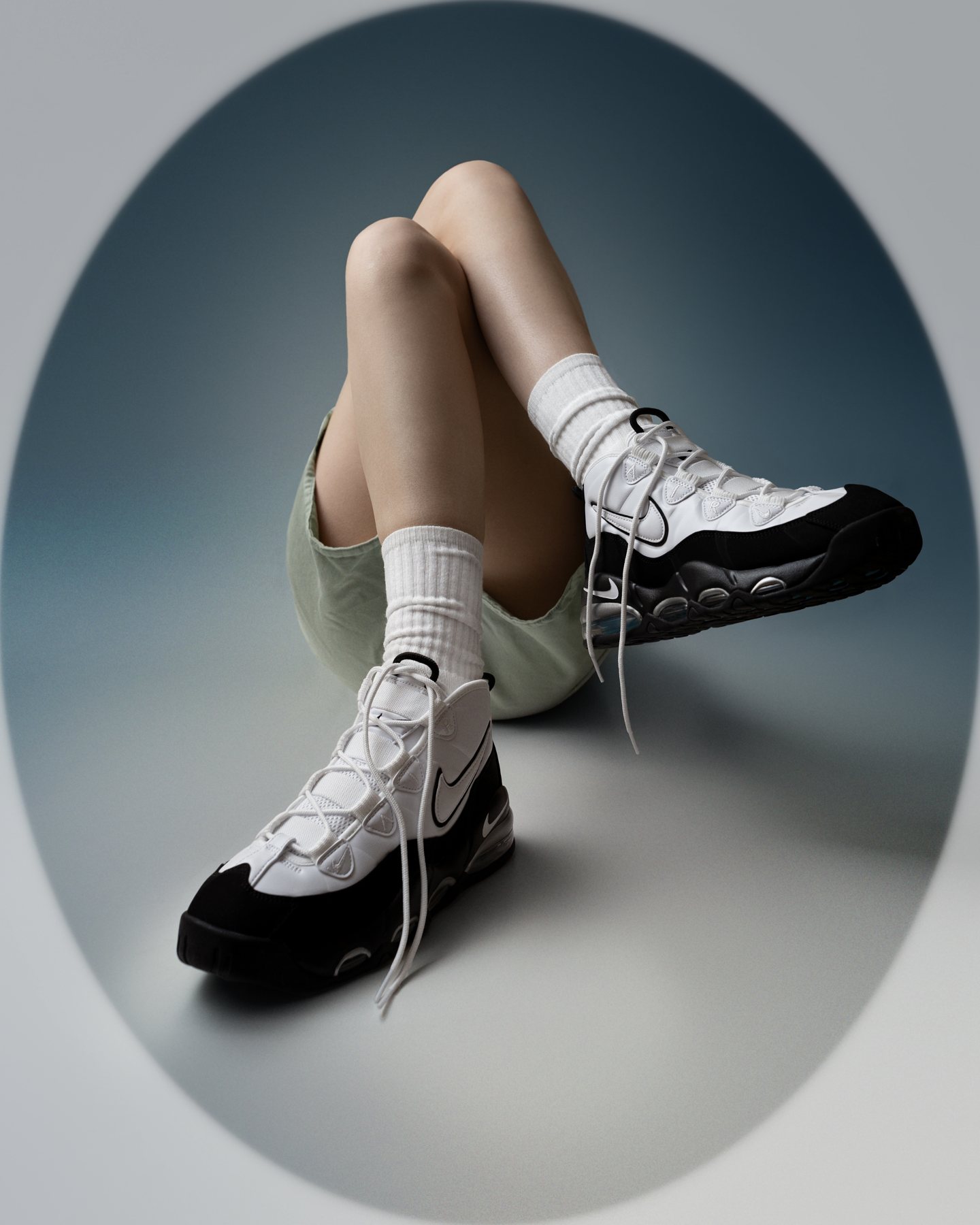 Sneaker shoot: Model seated in the black and white pair inside an oval of light